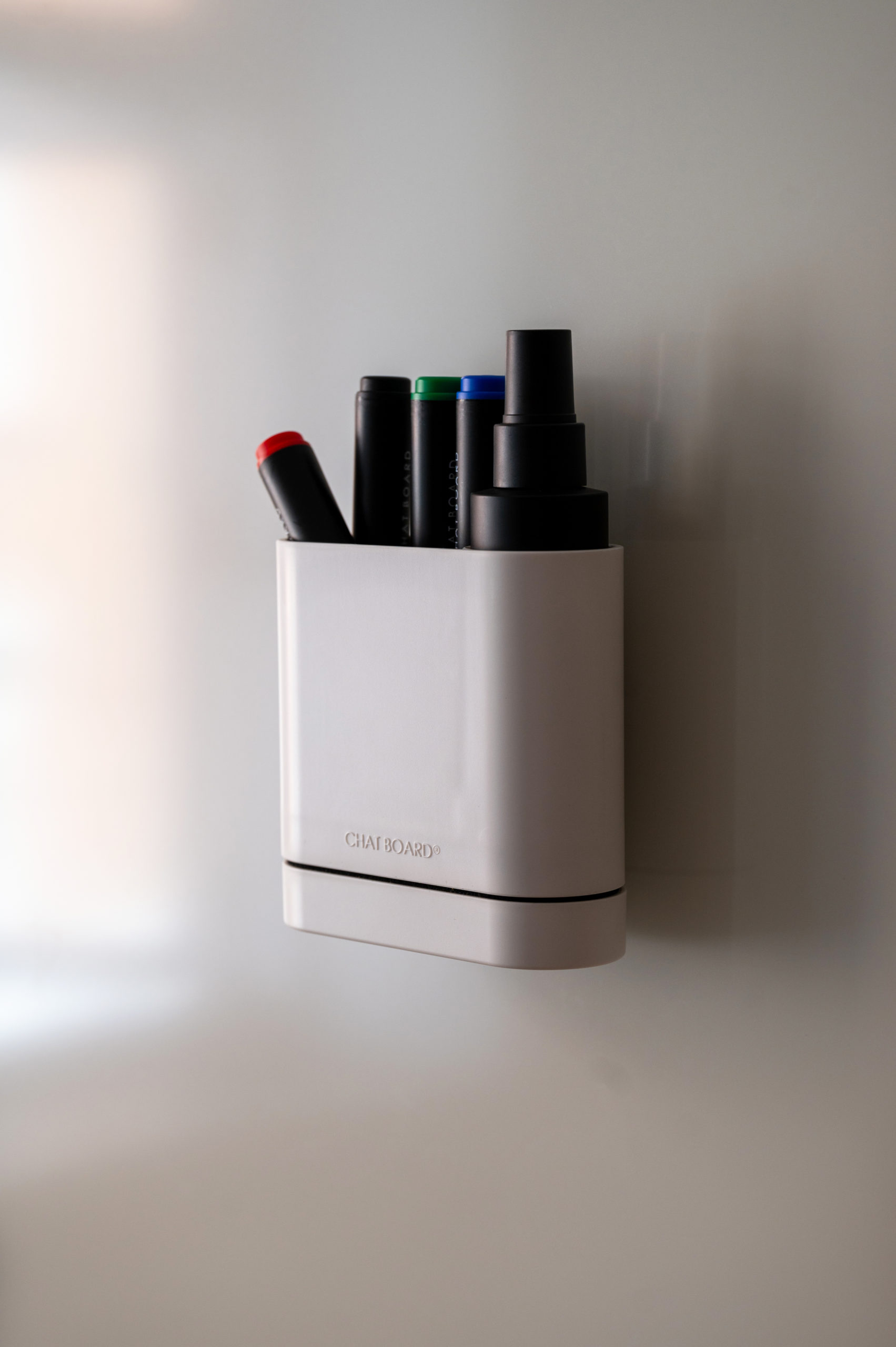 CHAT BOARD Dock storage unit with integrated eraser sponge - in white, shown with pens and cleaner spray - on Matt glass board in Sand